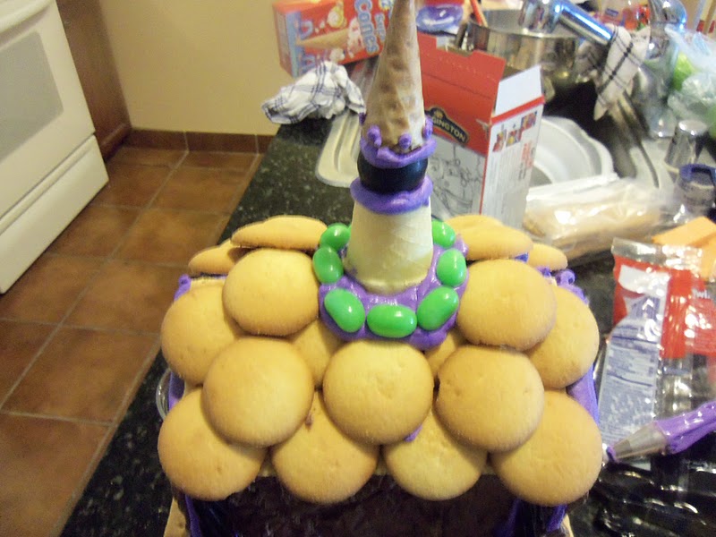 Attach mini Nilla Wafers around the roof to create shingles and decorate around the tower