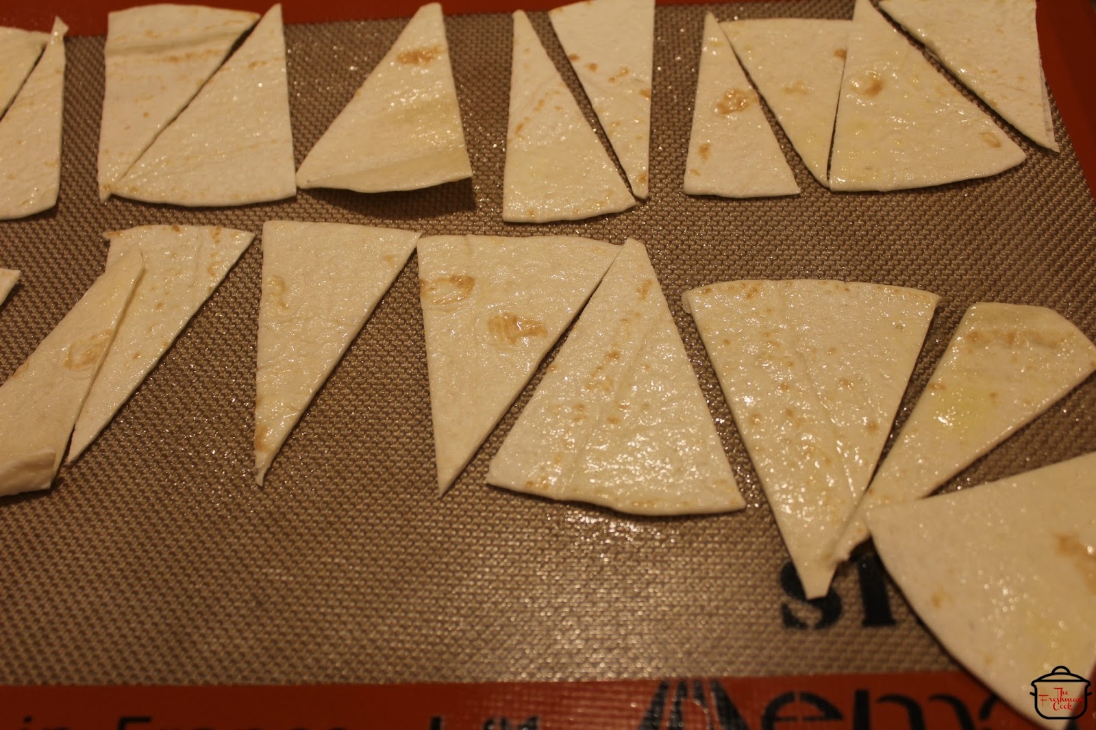 Cut the two tortillas into chips with a pizza cutter or pastry wheel. Arrange on a baking sheet, spray both sides with canola oil