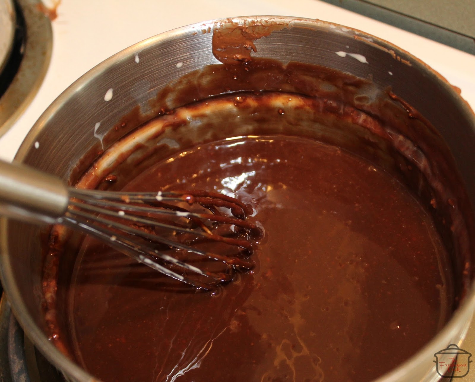 Gradually add 3–5 ounces of the cream to the melted chocolate, whisking continuously until smooth and slightly loose