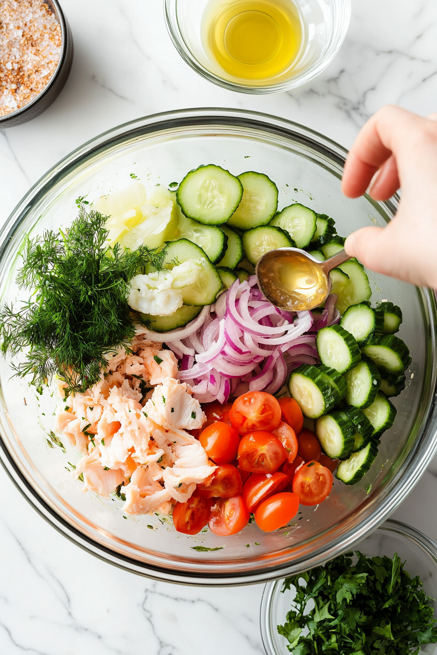 This image shows olive oil, lime juice, and rice vinegar being drizzled over the cucumber crab salad as a light and refreshing dressing