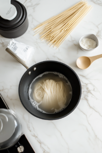 This image shows a large pot filled with boiling water and noodles, illustrating the cooking process as the noodles soften and prepare for the delicious hibachi dish.