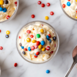 This image shows a freshly made homemade M&M McFlurry served in a cup, topped with extra mini M&M's for added crunch and color. The creamy ice cream mixture and vibrant candies create an irresistible dessert.