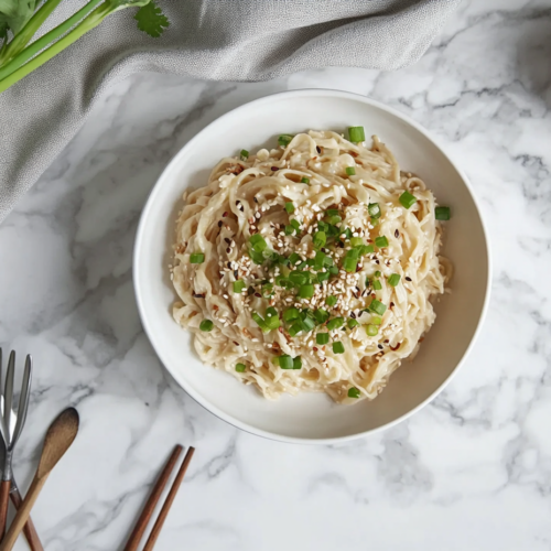 This image shows a plate of rich and buttery hibachi noodles, garnished with sesame seeds, highlighting the delicious textures and flavors that make this dish a perfect addition to any meal.