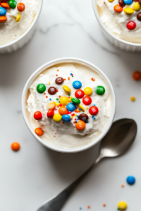 This image shows the mini M&M's being stirred into the creamy ice cream mixture with a spatula, ready to be served in cups for the perfect homemade McFlurry treat.