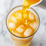 This image shows the cortisol cocktail for weight loss beautifully served in a glass filled with ice, featuring vibrant lemon slices, ginger, and turmeric, creating a refreshing and health-boosting drink.