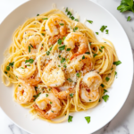 This image shows a delicious plate of shrimp scampi served with pasta, garnished with fresh parsley, perfect for an easy and flavorful Italian-inspired meal made in a slow cooker.