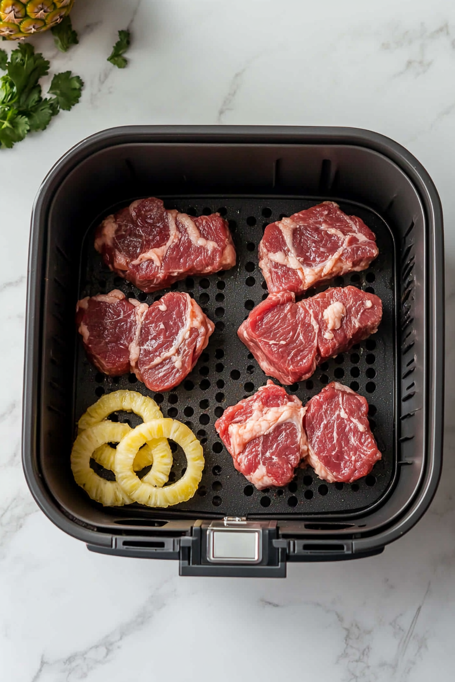 This image displays the glazed gammon steaks being placed inside the air fryer basket, ready to be cooked to perfection with minimal oil and effort.