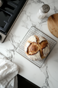 This image shows the freshly baked apple fritter bread cooling on a wire rack, allowing it to set and firm up before slicing into the warm, moist loaf.