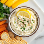 This image features a vibrant display of Cold Crab Dip, showcasing its creamy texture and rich ingredients, beautifully garnished and served with an array of crackers and fresh vegetables, ideal for any summer gathering.