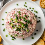 This image shows the completed chipped beef cheese ball, beautifully coated with chopped dried beef and green onions, served on a platter with crackers for a delicious and easy-to-share appetizer.