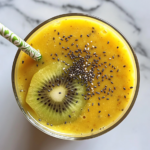 This image shows the finished Mango Kiwi Smoothie, beautifully served in a glass and garnished with fresh kiwi slices, offering a refreshing and nutritious drink perfect for any time of the day.