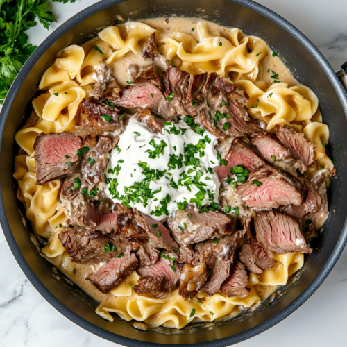 This image shows a bowl of rich and creamy leftover prime rib stroganoff, served over egg noodles and garnished with fresh parsley, creating a comforting and satisfying meal perfect for repurposing holiday leftovers.