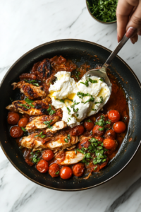 This image shows the cooked chicken and softened cherry tomatoes being combined in the skillet, creating a vibrant and flavorful dish that is ready to be plated.