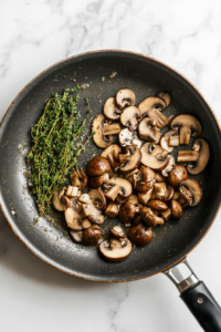 This image shows the stroganoff sauce gently simmering in a pan with beef broth, Worcestershire sauce, and mustard, thickening into a creamy and flavorful base.