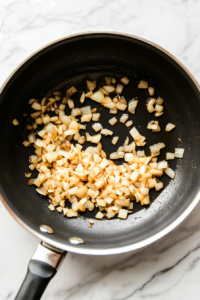 This image shows butter and flour being stirred together in a pan to create a smooth and golden roux that will thicken the rich stroganoff sauce.