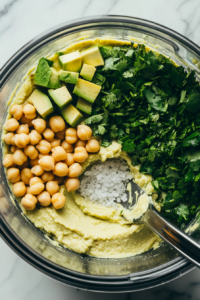 Blending Chickpeas Avocado and Tahini into Smooth Avocado Hummus