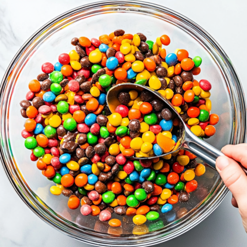 This image shows the fully prepared candy salad in a large serving bowl, filled with a variety of gummy candies such as peach rings, gummy bears, and Nerds gummy clusters. The vibrant colors and fun shapes make it a cheerful and enticing dessert, perfect for parties or sharing with friends.