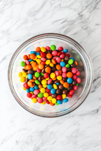 his image shows the candy salad being transferred into an airtight container. The mix of gummy candies is vibrant and filling the container to the brim, with the lid being placed on to keep the candies fresh and chewy, stored in a cool, dry place.