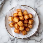 This image shows a close-up view of golden brown cubed hashbrowns with a crispy exterior and soft, tender interior, making them an ideal side dish.