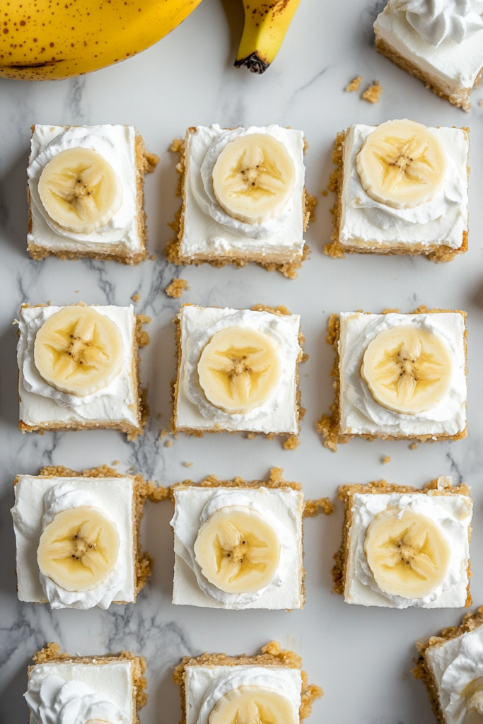 This image shows the smooth banana cheesecake filling being spread evenly over the chilled Nilla Wafer crust in the baking pan, creating the base for the dessert.