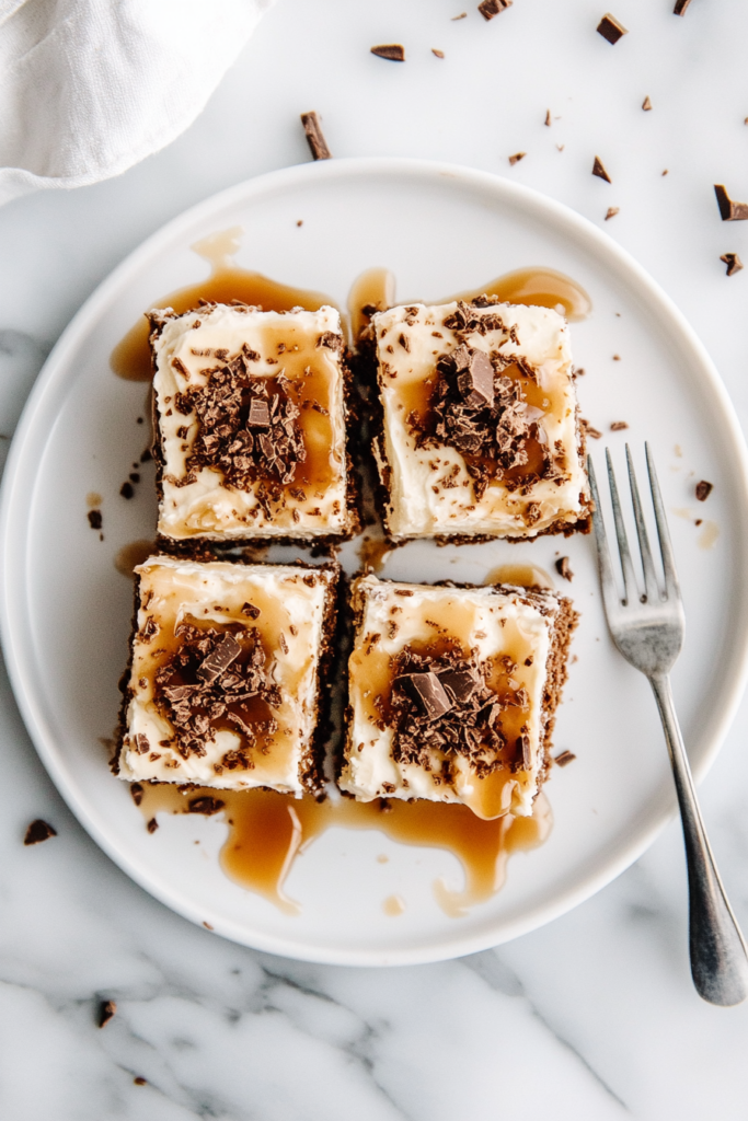 This image shows the chilled cheesecake bars being cut into squares and served on a plate, with a drizzle of caramel sauce for added decadence.