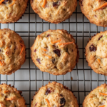 This image shows a plate of delicious and moist breakfast muffins, packed with wholesome ingredients like carrots, zucchini, banana, and dried cherries, perfect for a healthy start to the day.