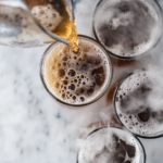 This image features a pitcher of homemade root beer with dry ice, highlighting the foggy and fizzy effect created by the dry ice, making it an eye-catching and festive beverage.