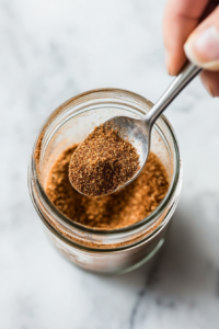 This image shows the freshly made spice rub being transferred into a mason jar for convenient storage, keeping it fresh and ready to use.