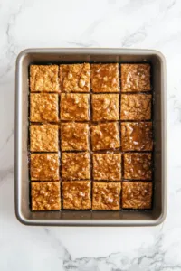 Top-down view of the baking pan with the toffee-coated graham crackers in the oven, bubbling and turning golden brown as they bake.