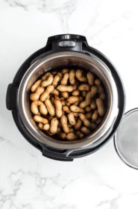 Top-down view of the Instant Pot display set to high pressure with 80 minutes on the timer, showing the cooking process for boiled peanuts.