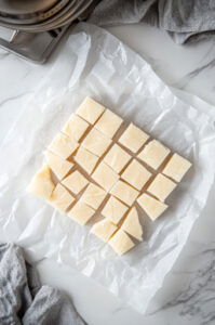 This image shows warm petit four icing being poured or spooned over the small cake shapes, fully coating them.