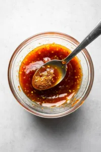 This image shows a bowl with mayo, mustard, ketchup, dill relish, smoked paprika, garlic powder, and onion powder being mixed together to create the special sauce.