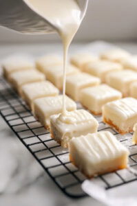 This image shows each iced petit four ona cooling rack