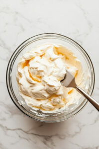 This image shows heavy cream being whipped in a separate bowl .