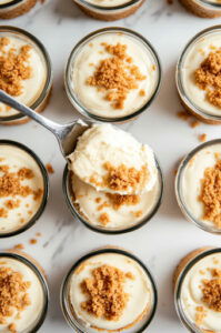 This image shows the cheesecake mixture being spooned into the cups over the graham cracker crust.