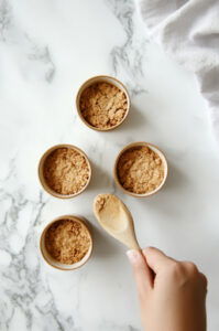 This image shows the graham cracker mixture being evenly distributed into 4 cups.