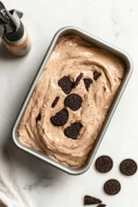 This image shows the smooth batter being poured into a greased bread pan, ready to be baked.