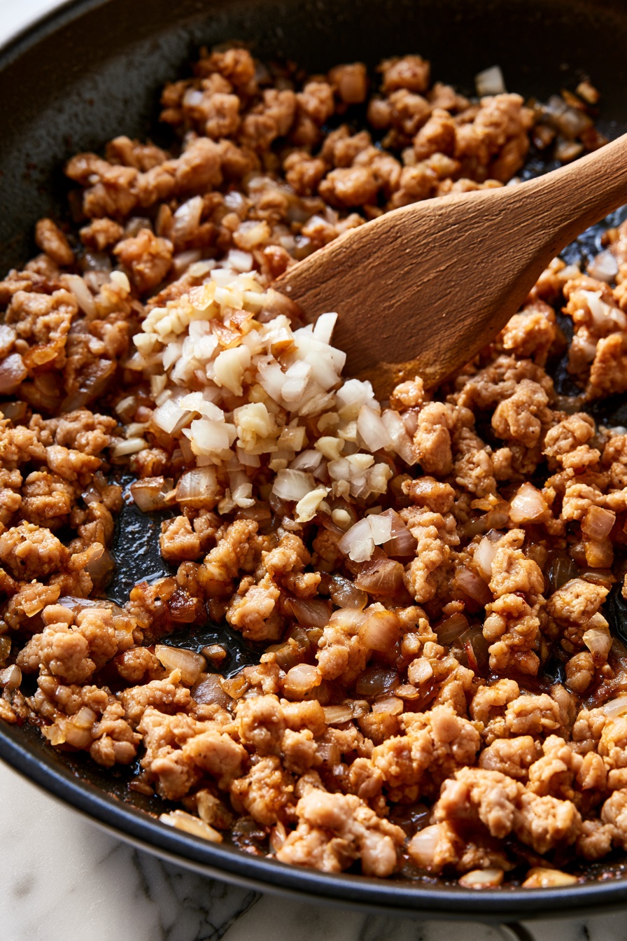 When the turkey starts to brown, add minced garlic and diced onion. Continue cooking until the turkey is fully browned and no longer pink