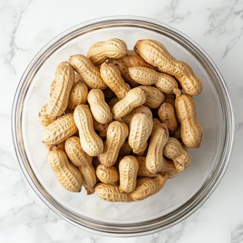 Top-down view of drained boiled peanuts served in a large bowl, ready to eat.