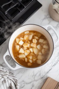 this image shows Potato cubes added to the pot and brought to a gentle simmer over medium heat.