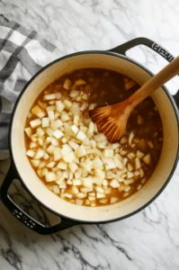 This image shows baby red potatoes and honeycrisp apple slices being added to the pot, tossed in the cider and Worcestershire sauce mixture.]