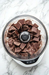 This image shows chocolate chunks being pulsed in a food processor until finely chopped.