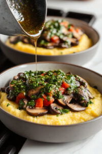 This image shows a generous amount of chimichurri sauce being drizzled over the polenta and mushrooms, adding a fresh and vibrant green touch to the dish.