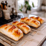 This image shows the freshly baked loaves being removed from the pans and cooling on wire racks.