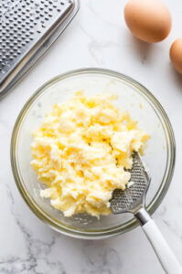 This image shows boiled eggs being grated over the potato cubes for a smooth texture.