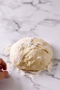 This image shows the dough being kneaded with the dough hook on speed 2 for 4 minutes, becoming smooth and elastic while remaining slightly sticky.