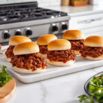 This image shows the completed Maid Rites sandwiches on a white plate, the warm buns filled with the seasoned beef mixture, ready to be eaten.