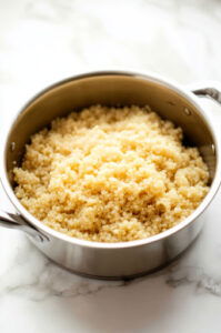 This image shows quinoa and broth being combined in a medium pot, cooking until the quinoa absorbs the liquid and becomes fluffy.