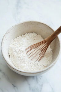 This image shows the dry ingredients being whisked together in a mixing bowl.