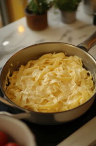 This image shows cooked pasta being mixed into the warm squash sauce, ensuring every piece is well coated.